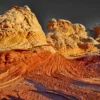 The first warm sunrise light reveals the full topographic detail of the golden and cream Navajo sandstone terraces at White Pocket, Vermilion Cliffs National Monument, Arizona. Fine art landscape photograph. Fujifilm GFX medium format.