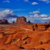 Red sandstone buttes of Monument Valley rise against a vivid blue sky with dramatic cumulus clouds, Navajo Tribal Park, Arizona-Utah border. Fine art landscape photograph. Fujifilm GFX medium format.