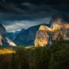 A winter storm breaks over Yosemite Valley — El Capitan lit in afternoon sun, storm clouds above, Bridalveil Fall visible at right. Tunnel View, February 2018. Nikon D810. Fine art photograph