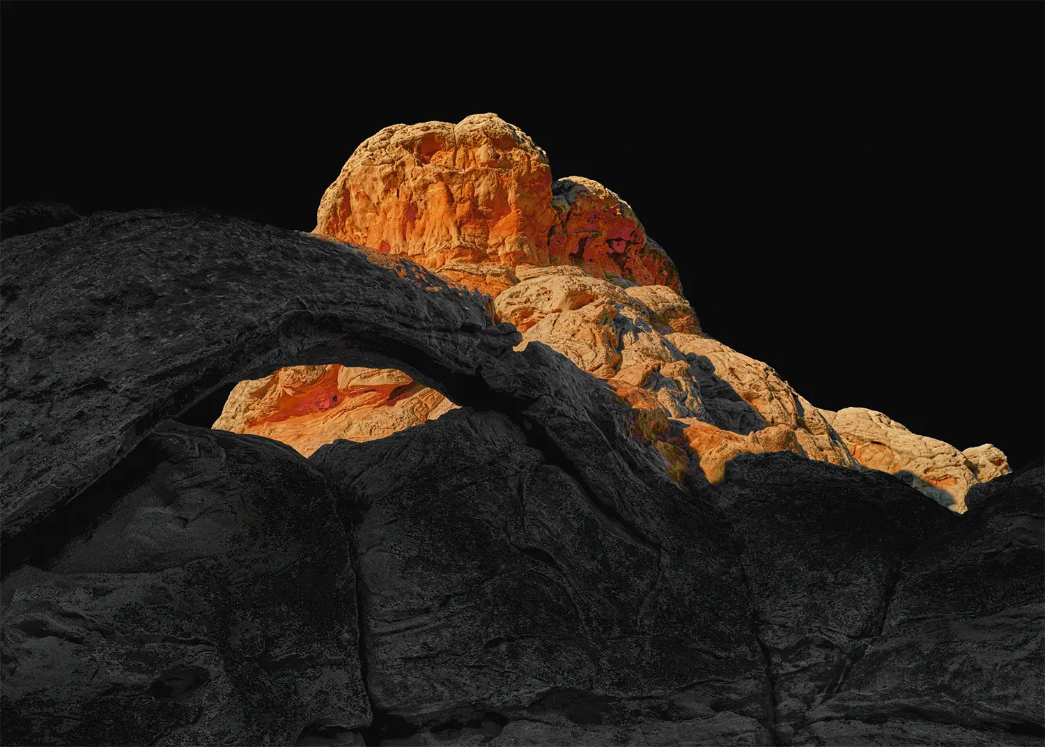 The Arch of White Pocket — glowing orange Navajo sandstone meets dark volcanic rock at the geological contact zone, Vermilion Cliffs National Monument, Arizona. Fujifilm GFX