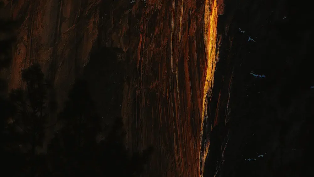 The rare February firefall phenomenon on Horsetail Fall, Yosemite Valley — the setting sun aligning with the east-facing granite face to illuminate the waterfall as burning orange fire. Yosemite National Park, California. Fine art landscape photograph. Nikon D810.