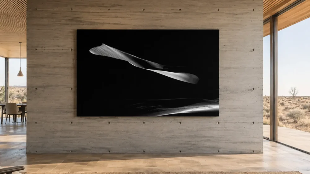 Gravity of Sand — Eureka Dunes black and white fine art print on a board-formed concrete wall in a wabi-sabi desert modernist residence, high-desert view beyond glass.