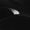 A single arc of white dune sand curves against pure black shadow at Eureka Dunes, Death Valley National Park. Square-format black and white fine art photograph. Fujifilm GFX medium format