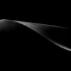 A single silver-lit dune ridge extends across pure black shadow at Eureka Dunes, Death Valley National Park. Signature Series panoramic black-field fine art photograph. Phase One medium format